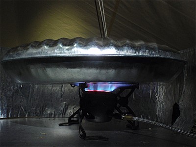 金属製の湯たんぽ をストーブで温める