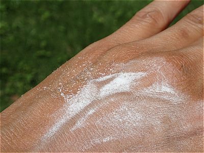 パフで粉をポンポンと皮膚に付ける