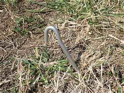 土にアルミ製丸ペグを打ち込む