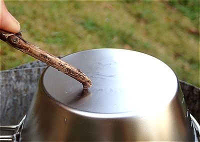 スプーンや木の枝などをシェラカップに当てて炊き上がりを確認
